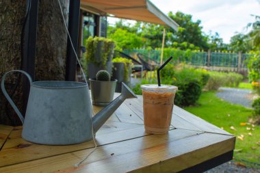 Bahçedeki ahşap bir masa üzerinde buzlu kahve.