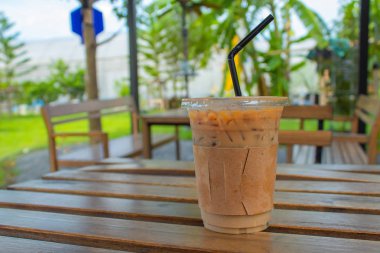 Bahçedeki ahşap bir masa üzerinde buzlu kahve.