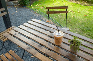 Bahçedeki ahşap bir masa üzerinde buzlu kahve.