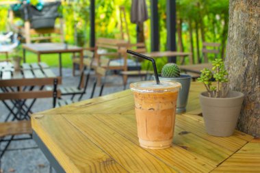 Bahçedeki ahşap bir masa üzerinde buzlu kahve.