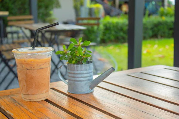 Bahçedeki ahşap bir masa üzerinde buzlu kahve.