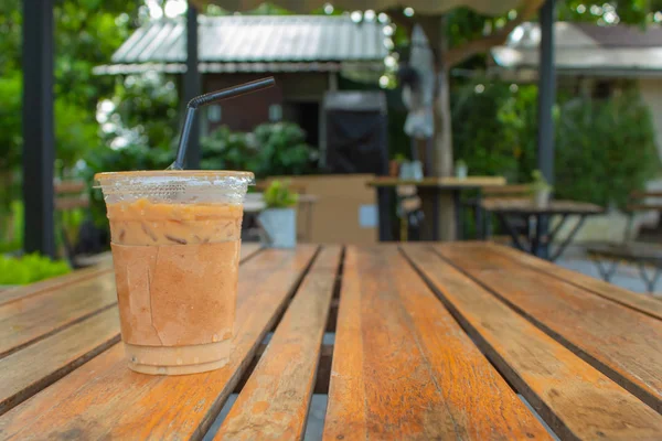 Bahçedeki ahşap bir masa üzerinde buzlu kahve.