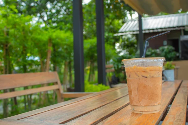 Bahçedeki ahşap bir masa üzerinde buzlu kahve.