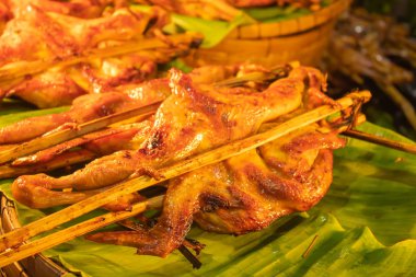 Izgara tavuk, muz üzerinde bambu yaprakları.
