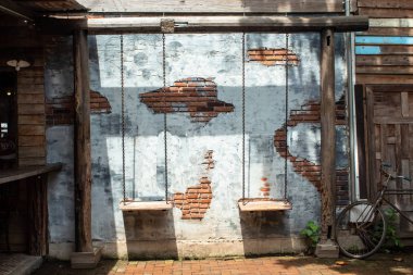 Salıncak sandalye ve eski sıva duvarlar.