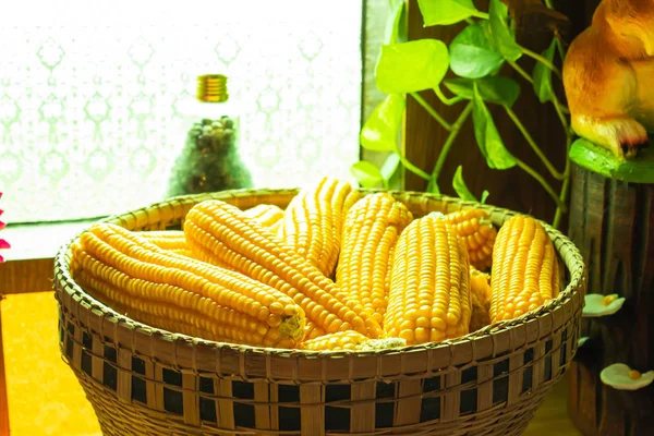 木桌上的竹篮中的黄色玉米 — 图库照片