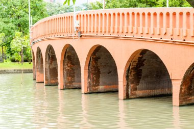 Beton köprü genel bir parkta gölet geçerken.