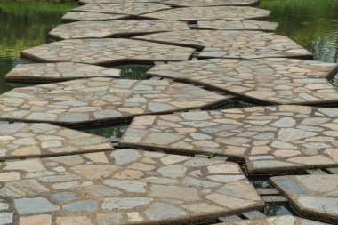 Beton köprü genel bir parkta gölet geçerken.