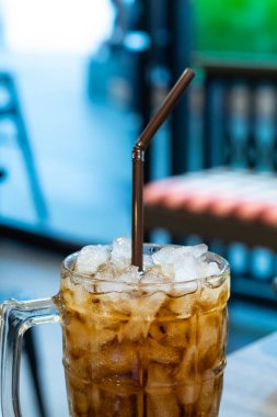 Gazlı su masada bir bardak buz ile.