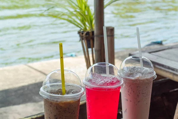 Cold drink on a wooden table by the river.