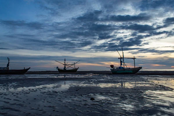 The morning sun light in the sea, and the boat on the beach.