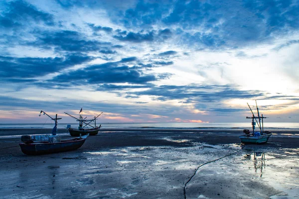 The morning sun light in the sea, and the boat on the beach.