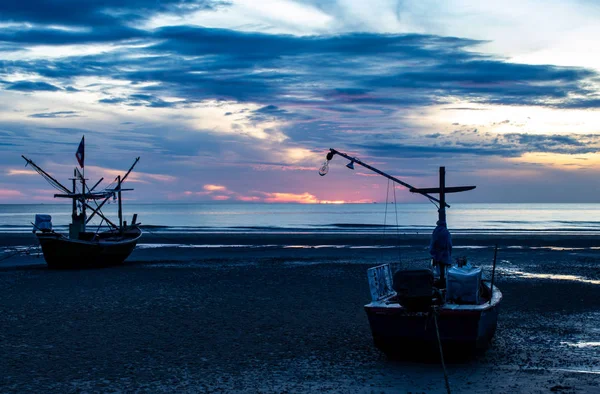 The morning sun light in the sea, and the boat on the beach.