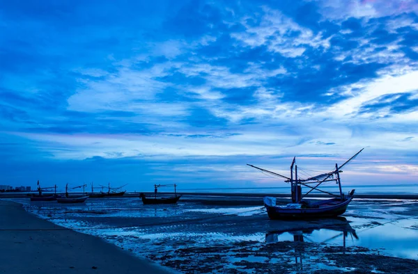 The morning sun light in the sea, and the boat on the beach.