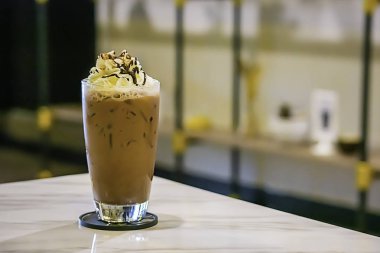 Buzlu kakao yerine bir cam masanın üzerine krem şanti.