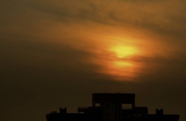 Büyük binalar üzerinde parlayan sabah erken güneş ışığı.