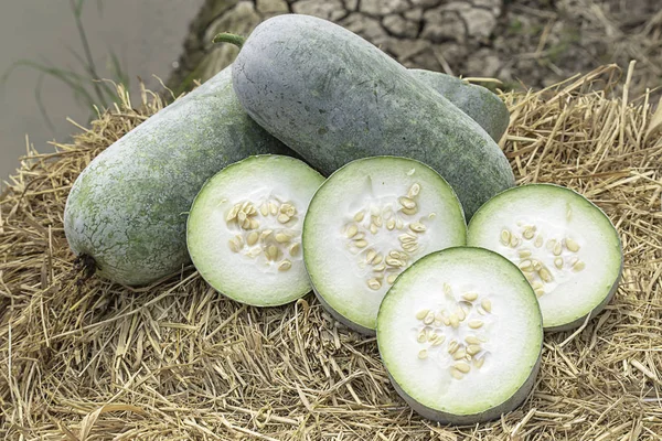 Winter melon is cut into pieces on the straw.