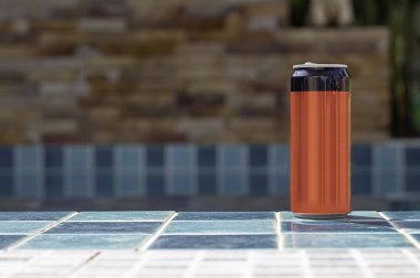 Havuzun yanında kiremitli yerdeki konserve içecek kırmızı ve siyah.