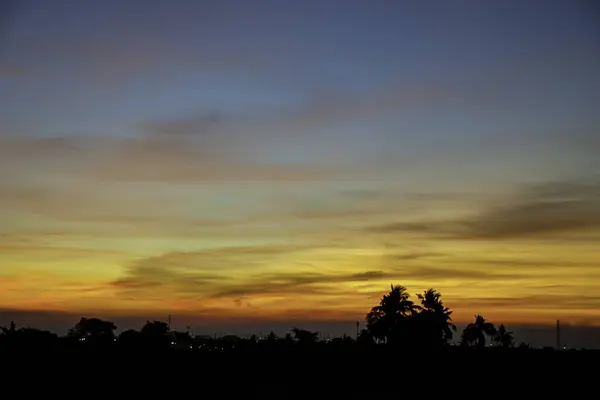 Sonnenuntergang das Abendlicht durch Wolken und Bäume. — Stockfoto