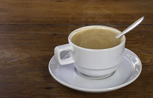 Ζεστό καφέ σε λευκό γυαλί στο ξύλινο τραπέζι — Φωτογραφία Αρχείου