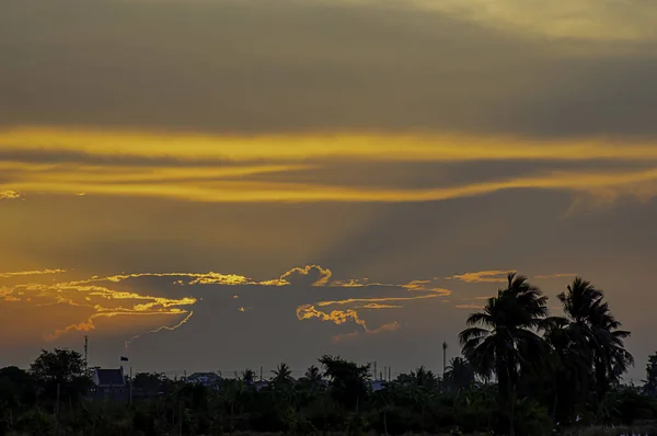 Atardecer la luz de la tarde a través de las nubes y árboles . — Foto de Stock