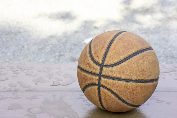 Cuero de baloncesto en la silla de madera con gotas de agua . —  Fotos de Stock