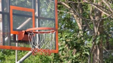 Basketbol çemberleri ve topu sallayarak ağlar bir parkta Arka plan ağaçları düştü