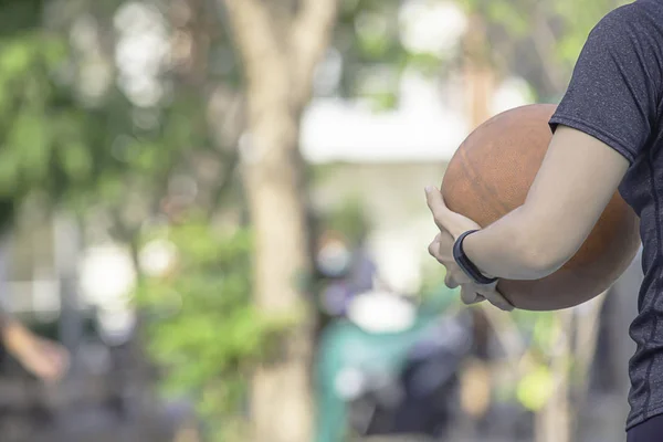 Hand einer Frau, die eine Uhr trägt und alten Basketball hält . — Stockfoto