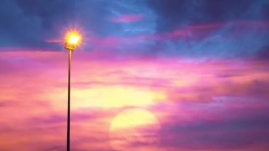 Gün batımı ışığını aydınlatan sokak ışığı ve gökyüzünde hızla hareket eden Kara yağmur bulutları.