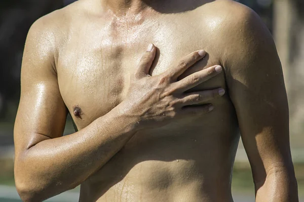 The hand grips the chest that inflammation from a sports injury.