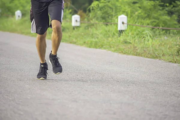 The men are running on the road Background trees. — Stock Photo, Image