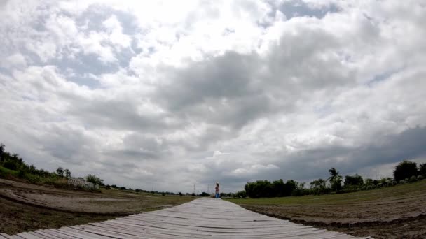 木桥和太阳的反射与雨云在稻田的天空快速移动 — 图库视频影像