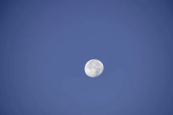 Tidsfördröjning rörelse kratrar på ytan av fullmåne i dagsljus på den ljusa himlen. — Stockfoto