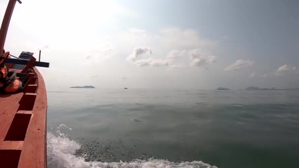 Zobrazit video na rybářské lodi jedoucí v moři a stříkající vody Pozadí ostrova a mraky na jasné obloze. — Stock video