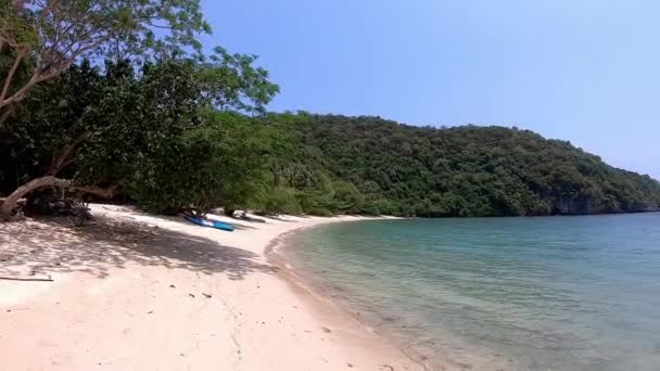 De video beweegt van links naar rechts van Kajak op de zandstranden en lichtgolven in de baai Achtergrond zee en eiland op koh Kula, Chumphon, Thailand. — Stockvideo