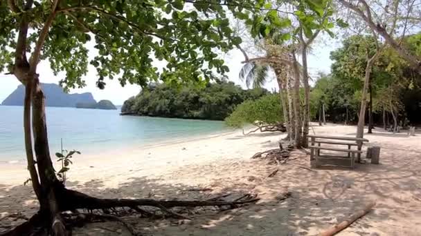 動画は右から砂浜の左側へ移動し、湾内の光の波背景海と島(タイ、チュンポン島). — ストック動画