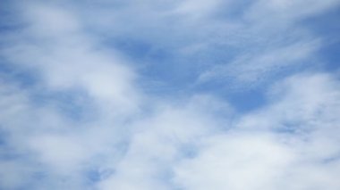 Hızlı hareket eden beyaz bulutlar gündüz vakti gökyüzünde hızla hareket ediyor..