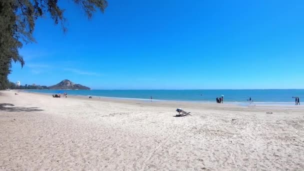 Video se pohybuje zleva doprava turistů na písečných plážích a světlých vlnách Pozadí moře na Suan Son Pradipat Beach, Prachuap Khiri Khan v Thajsku. 16. února 2020