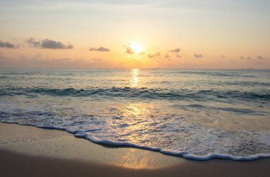Sahile vuran deniz dalgaları Arkaplan bulutları ve güneşin altın ışığı Sabah gökyüzünde Thung Wua Laen Sahili, Chumphon, Tayland.