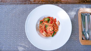 Üst görüntü Masa örtüsü üzerinde beyaz tabakta baharatlı karides.