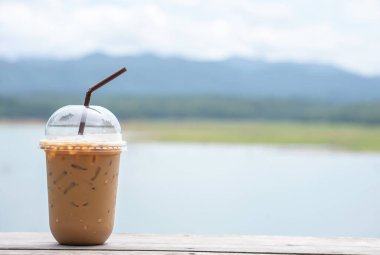 Masaya bir bardak soğuk espresso. Arka plan bulanık. Gökyüzü suyu ve dağ manzarası..
