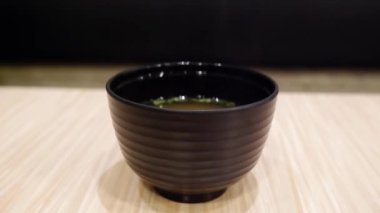 Siyah et suyu bardağının kapağını aç ve beyaz duman ahşap masada yüzüyor..