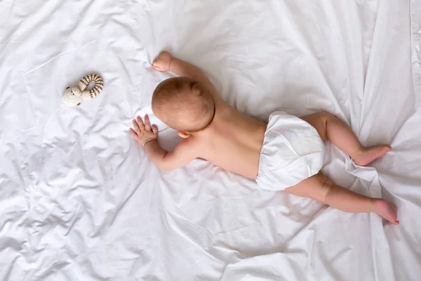 Cute baby lies in a white round bed