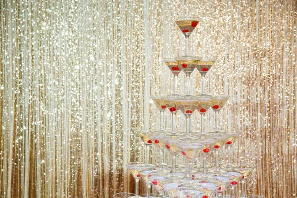 波光粼粼的香槟金字塔 在金色墙壁前的聚会上的眼镜塔 — 图库照片