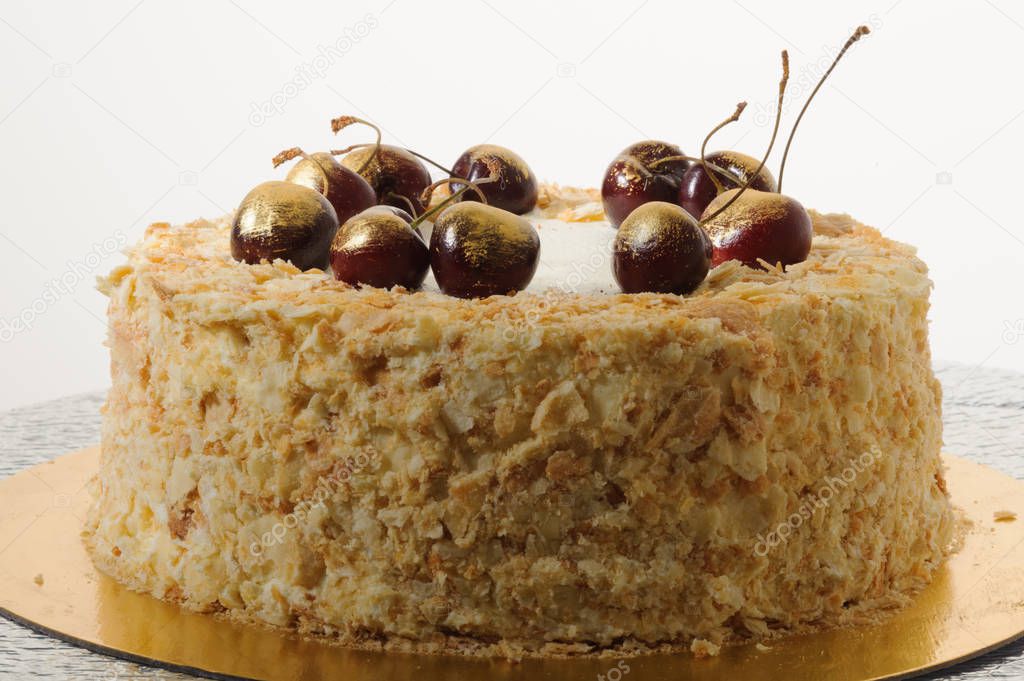 golden napoleon decorated cake with cherry, homemade pastry shop, handmade.
