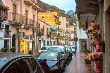 Cityscape manzaralı daire ev ve yayalara Giardini Naxos Taormina yakınındaki yağmurlu alacakaranlıkta. Sicilya, İtalya