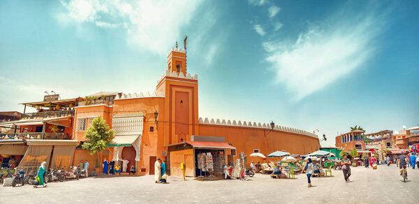MARRAKESH, MOROCCO - JULY 03, 2018: Panoramic view of famous market square Djemaa el Fna with mosque and minaret at Marrakesh's Medina quarter.  North Africa