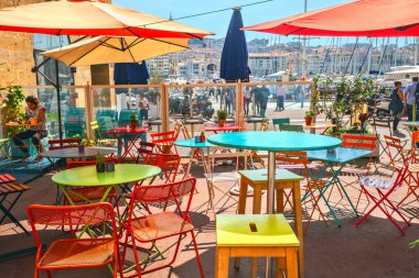 MARSEILLE, FRANCE - 01 Ekim 2017: Renkli masaları, sandalyeleri ve iskele manzaralı Summer Street Cafe. Kaynak
