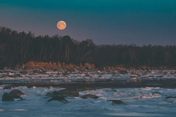 Kış sabahına kadar deniz kıyısında doğal moonset
