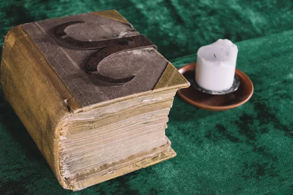 Ortaçağ masasında eski ağır kitap ve mum